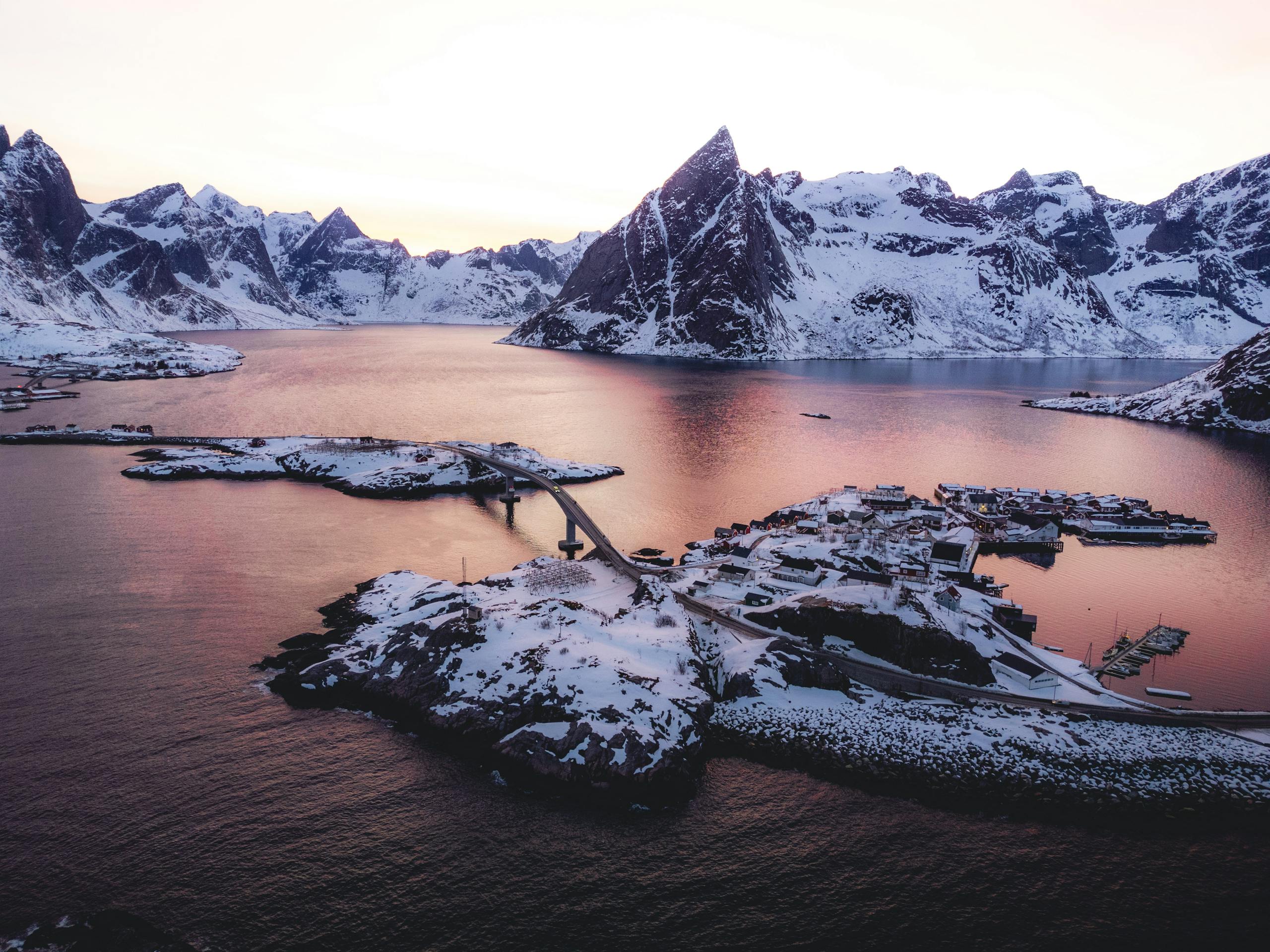 A photo of a snowy mountain range with a boat in the water